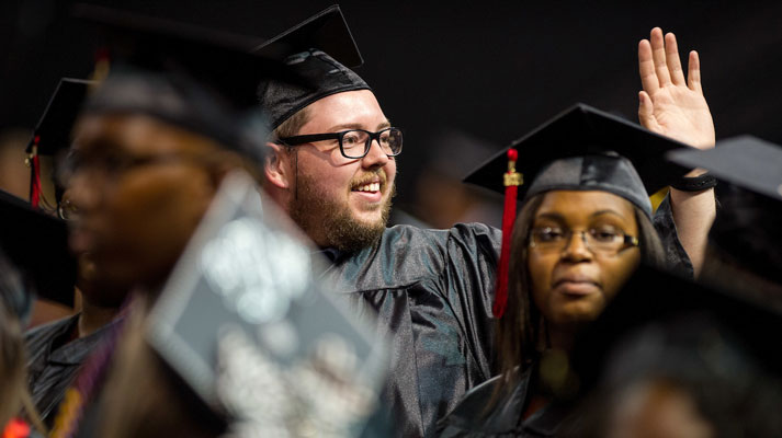 Smiling graduate waving