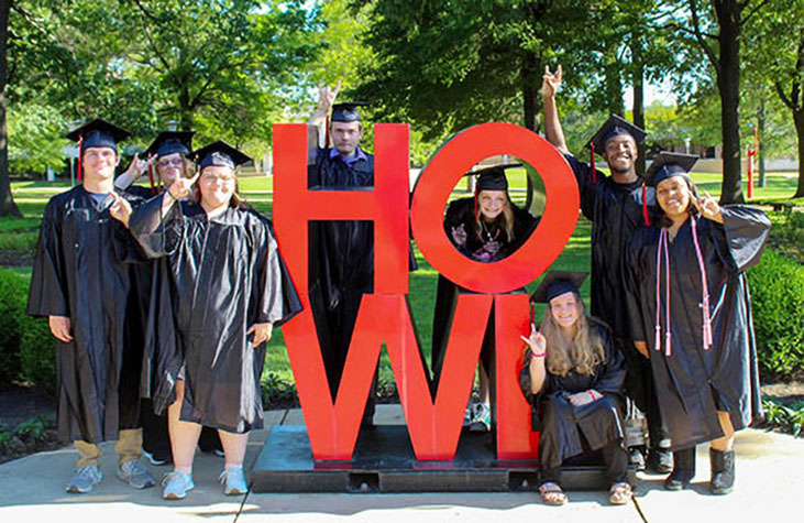 2023 H.O.W.L. transition program students pose in front of the HOWL art work on A-State's Jonesboro campus